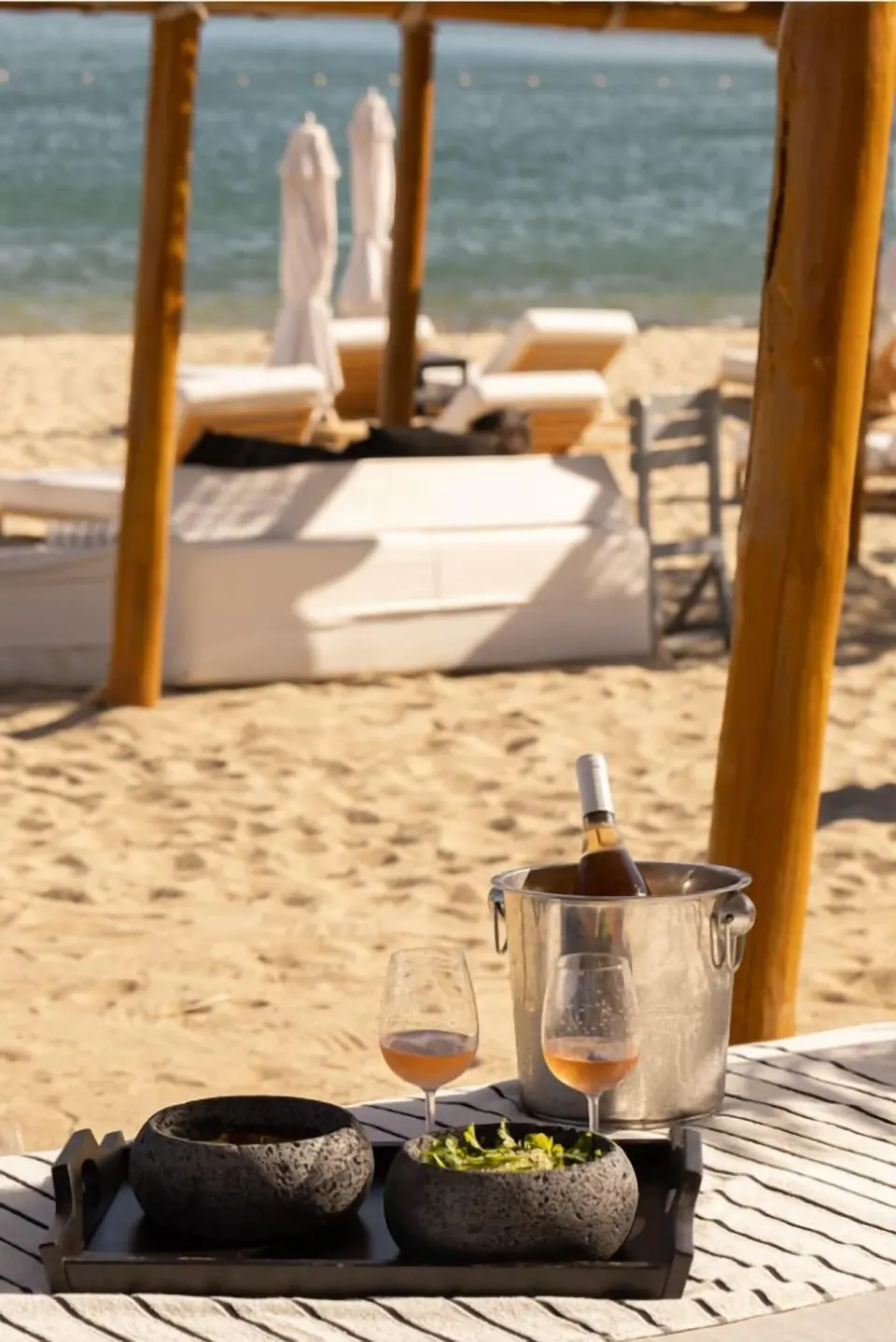 Wine bottle in an ice bucket on a beach table at Hotel El Ganzo.