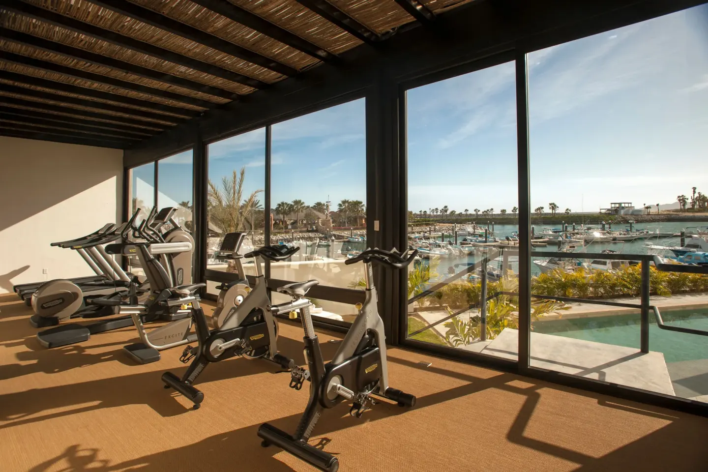 Fitness room with bikes and cardio machines facing the marina at Hotel El Ganzo.