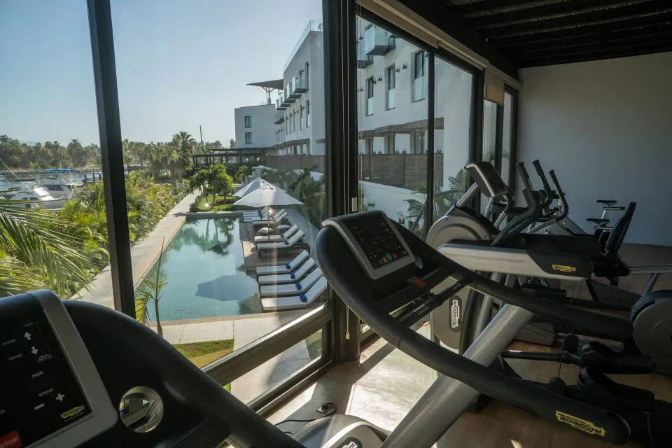 Fitness room cardio machines overlooking the pool and marina at Hotel El Ganzo.