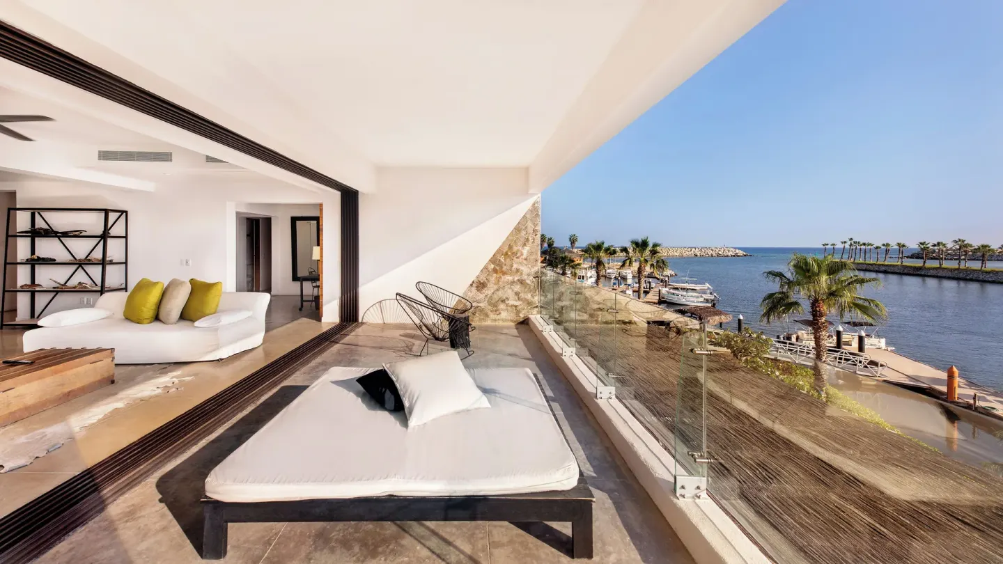 Guest terrace at Hotel El Ganzo with a daybed, lounge seating, and marina water view.