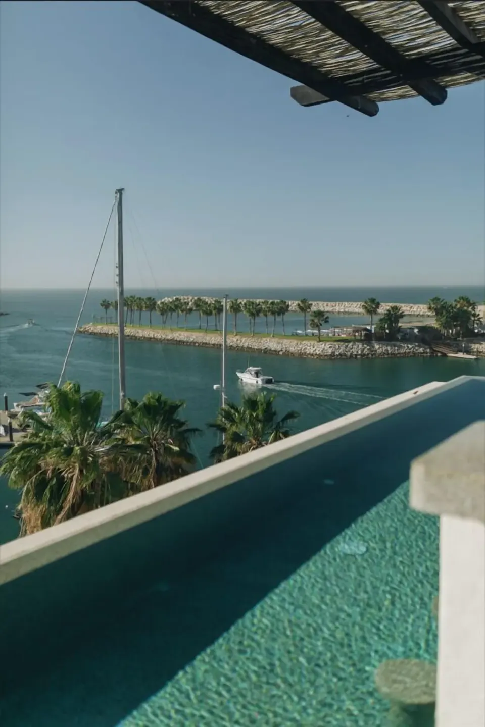 Infinity pool edge overlooking marina channels and palms at Hotel El Ganzo.