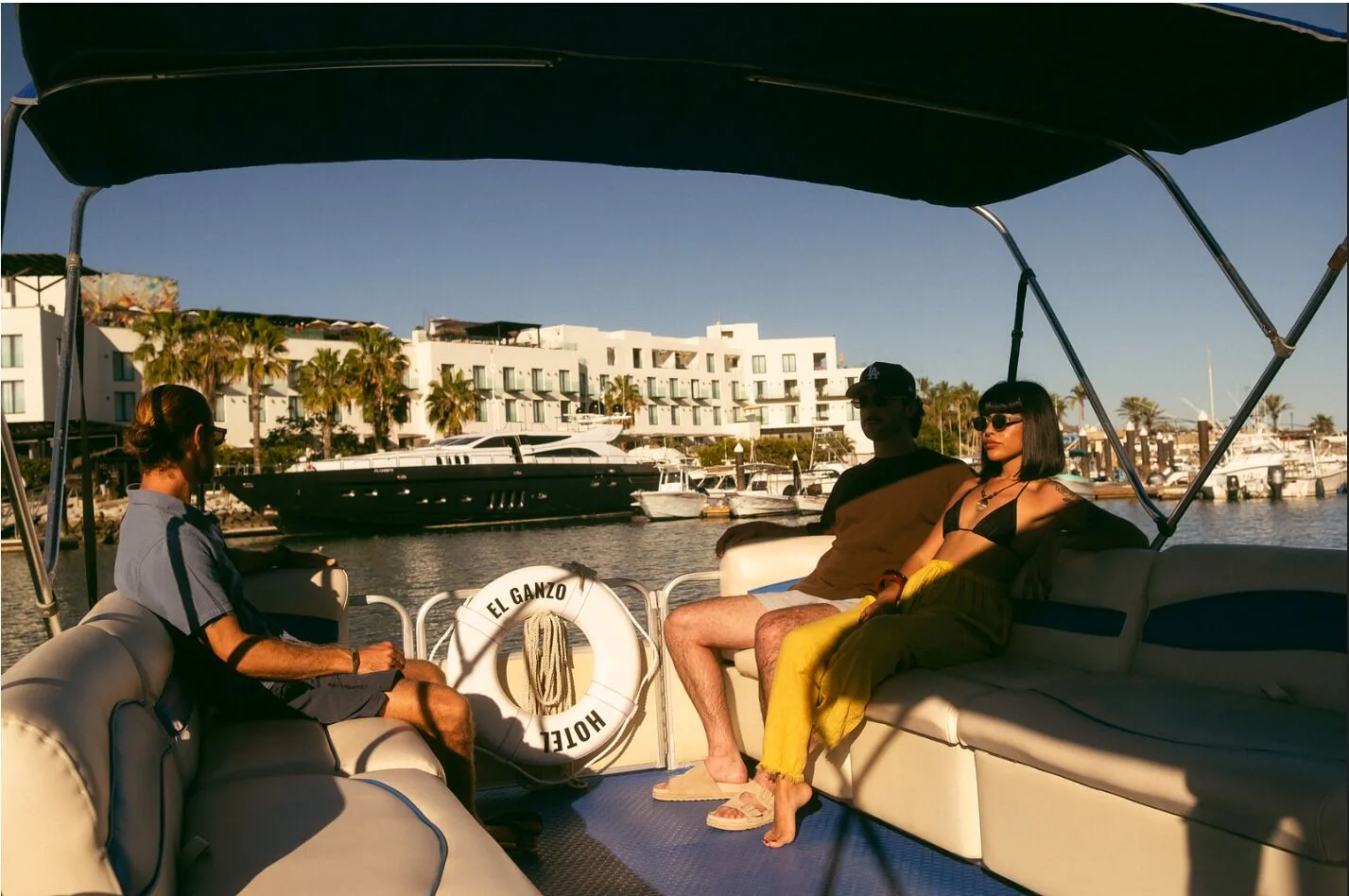 Guests ride a boat past the marina and white resort buildings at Hotel El Ganzo.
