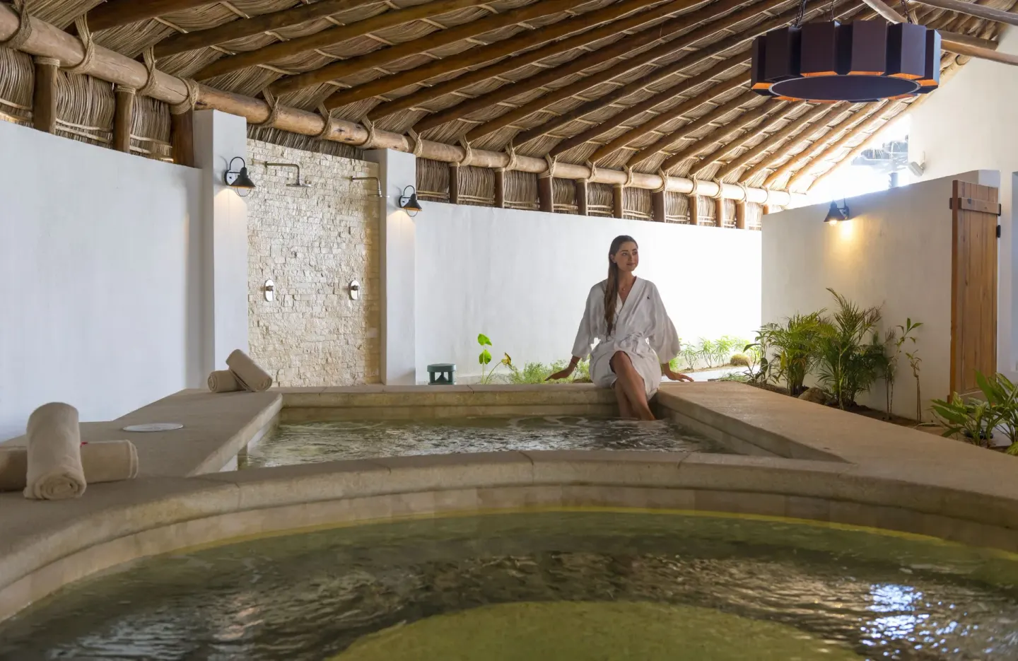 Spa hydrotherapy pools under a thatched roof at Hotel El Ganzo.