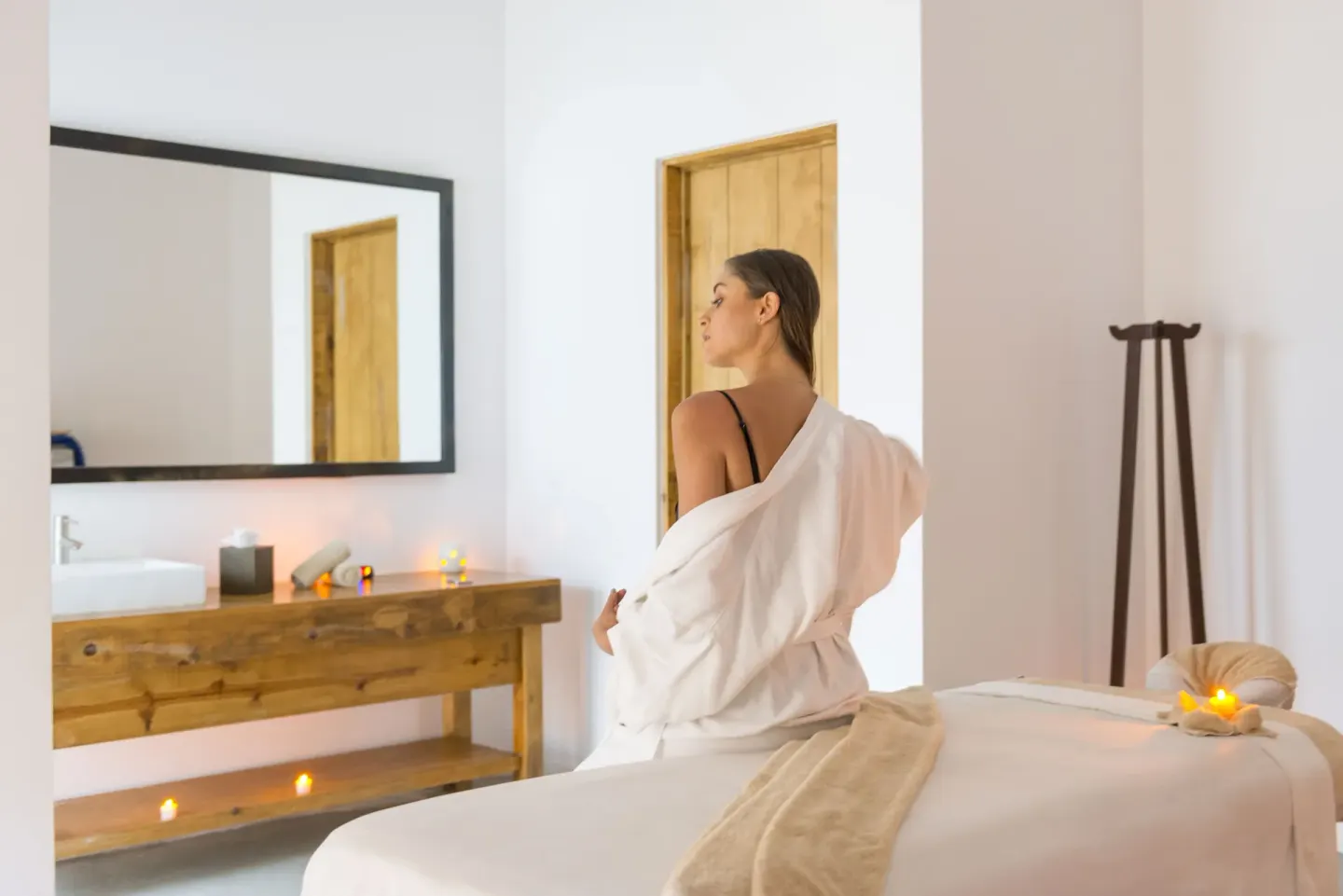Spa treatment room with massage table, candles, and vanity at Hotel El Ganzo.