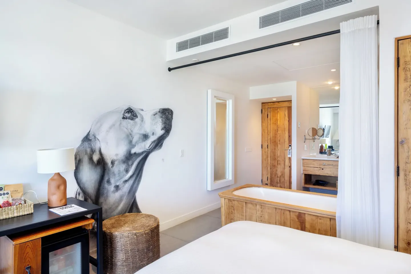 Ocean View Two Beds room detail with dog mural, tub, and vanity at Hotel El Ganzo.