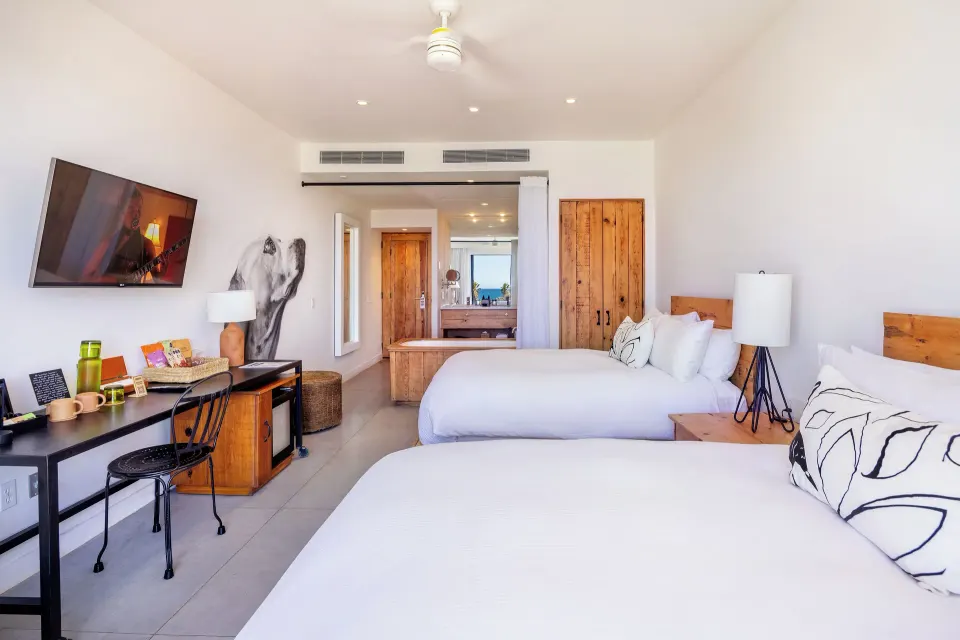 Ocean View Two Beds guest room with desk, tub, and white bedding at Hotel El Ganzo.