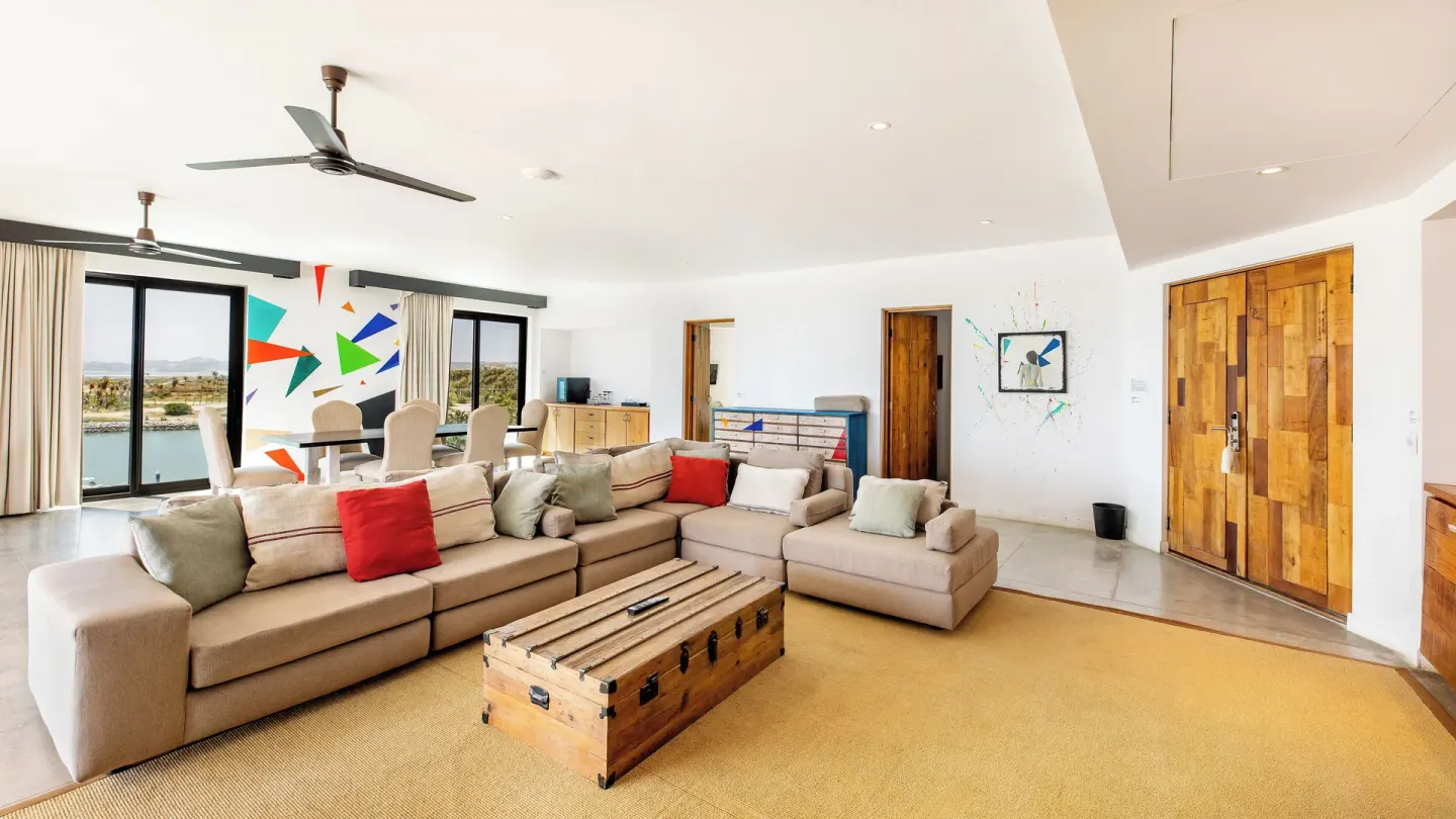 Penthouse Suite One Bedroom living and dining area at Hotel El Ganzo with sofas, art, and balcony doors.