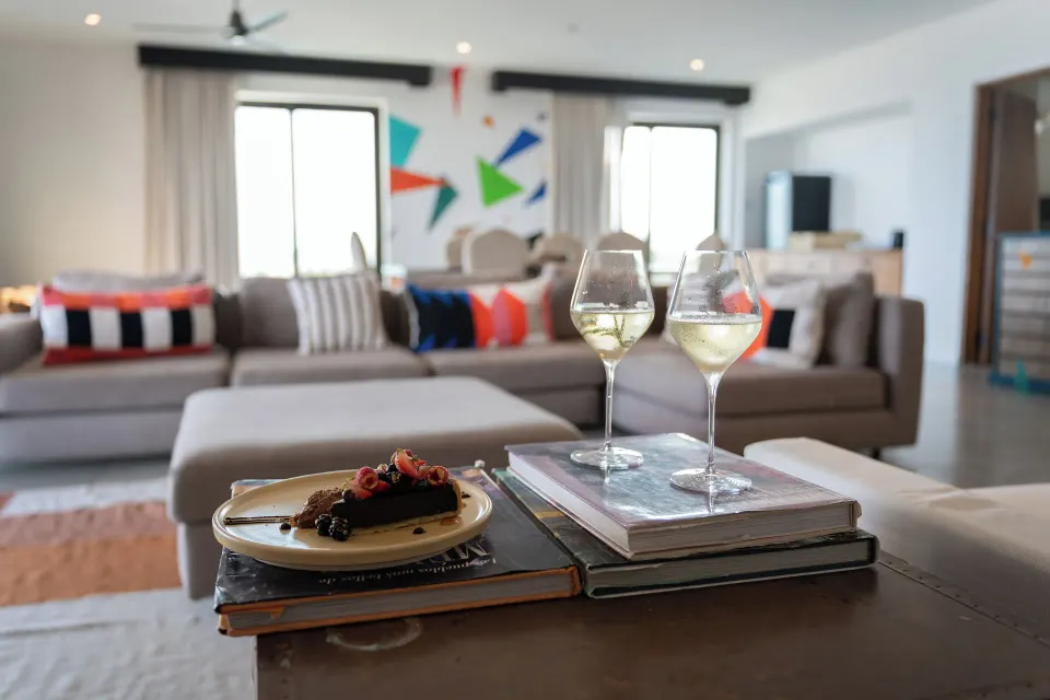 Penthouse Suite One Bedroom table at Hotel El Ganzo with wine glasses and dessert in the lounge.