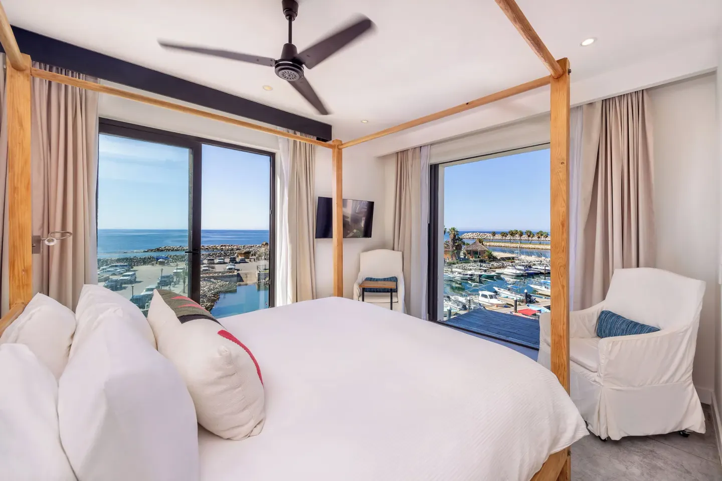 Standard Suite bedroom with white four-poster bed and water views at Hotel El Ganzo.