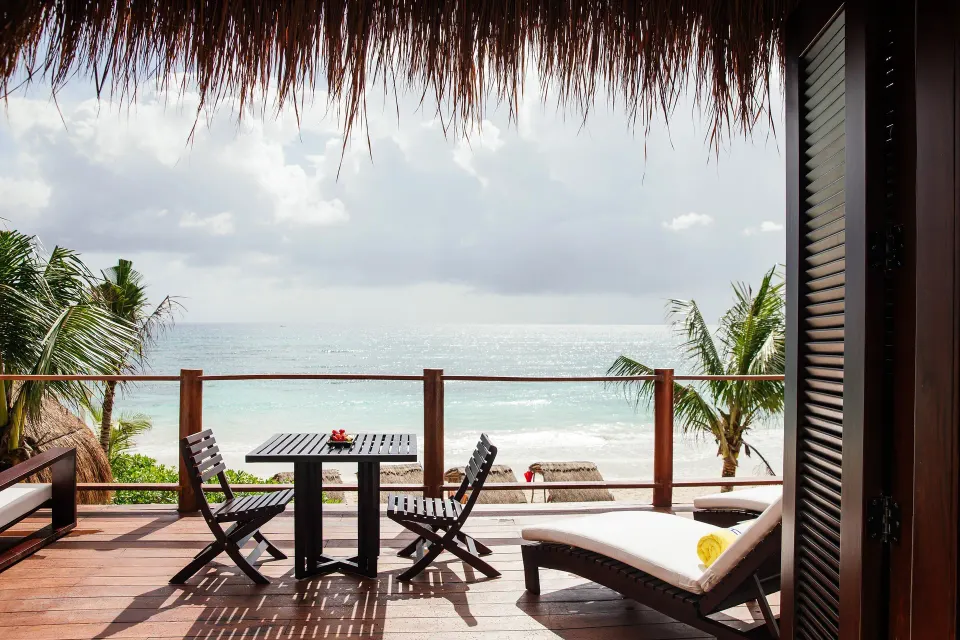 Private terrace at Hotel Esencia with table, chairs and direct ocean view.