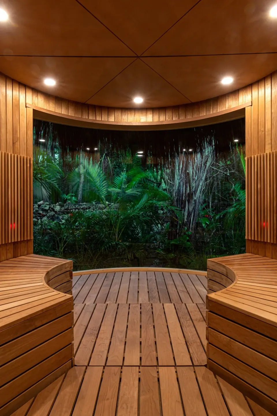 Wooden circular sauna interior overlooking nighttime jungle at Hotel Esencia