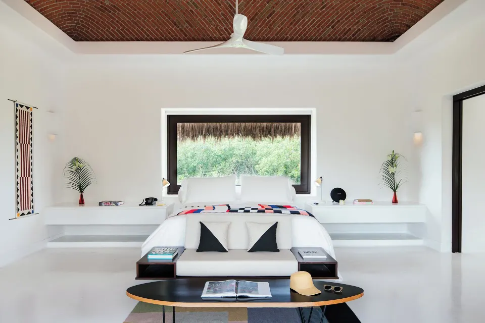 Symmetrical suite with king bed centered under a brick-domed ceiling at Hotel Esencia.