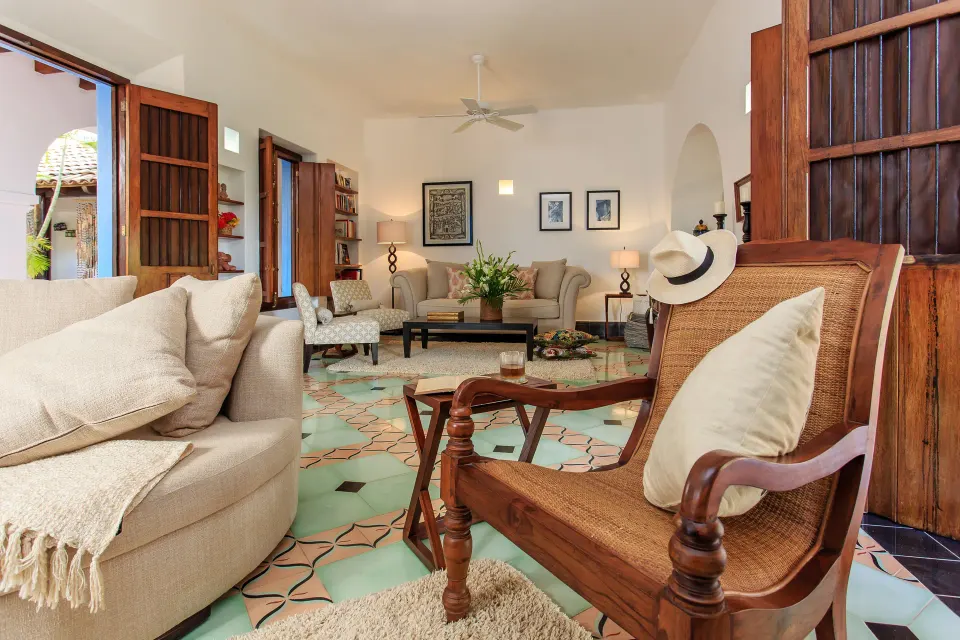 Cozy indoor lounge with patterned floor tiles and wooden shutters at Hotel Esencia.