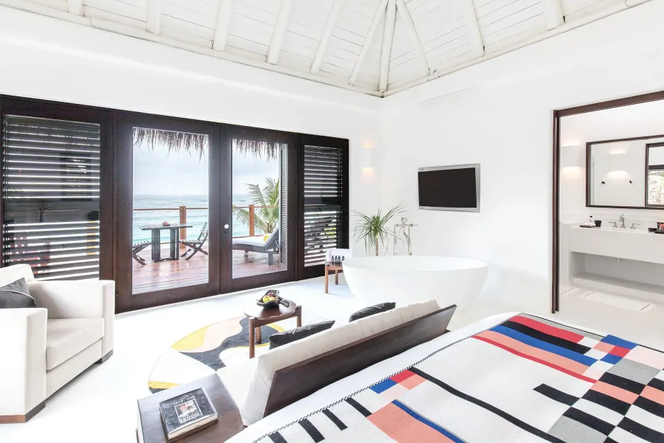 Spacious suite with freestanding tub and ocean-facing doors at Hotel Esencia