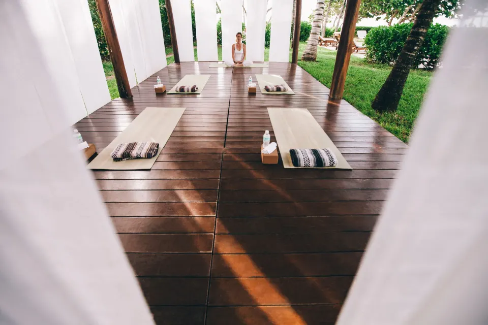 Open wooden treatment platform with mats and a therapist at Hotel Esencia