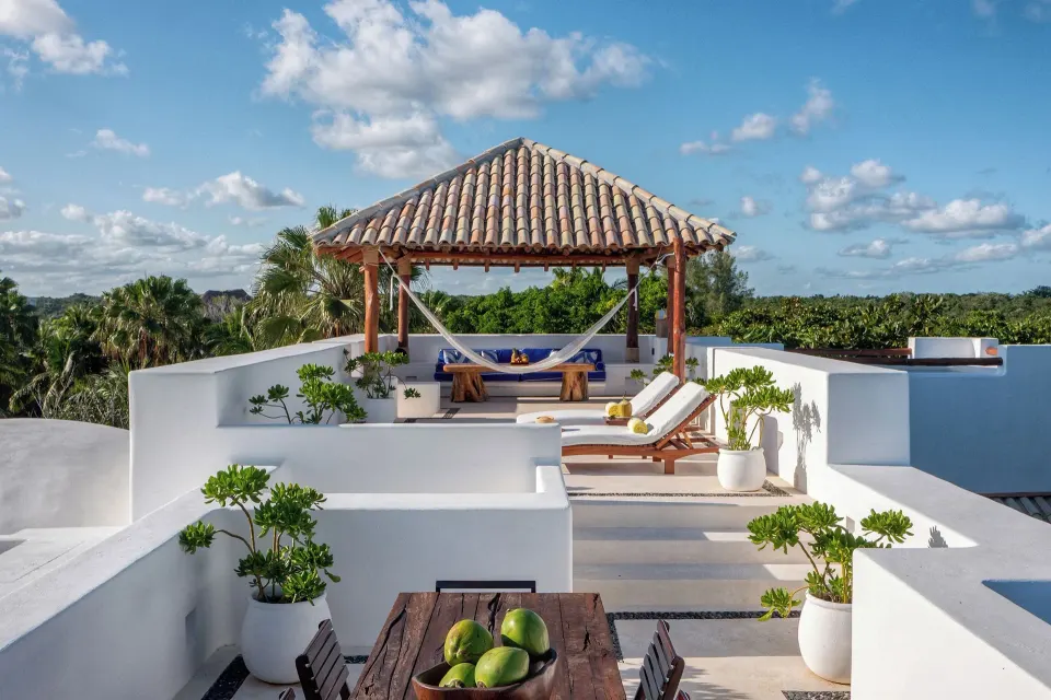 Rooftop lounge and dining area with pergola and ocean at Hotel Esencia