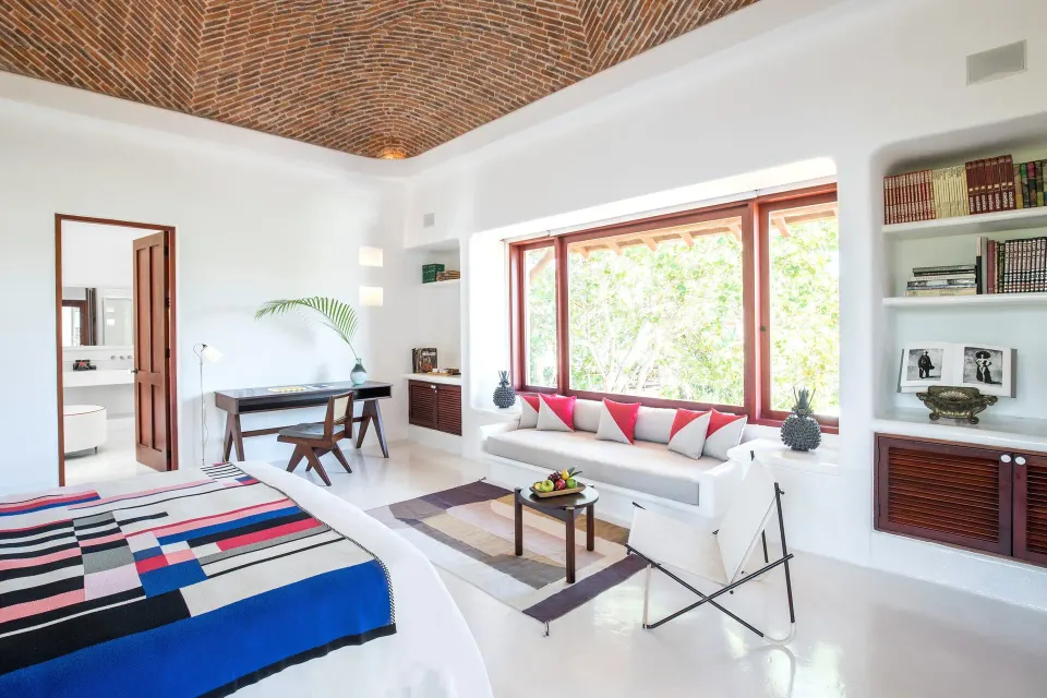 Spacious suite with woven brick ceiling, large window seat and king bed at Hotel Esencia