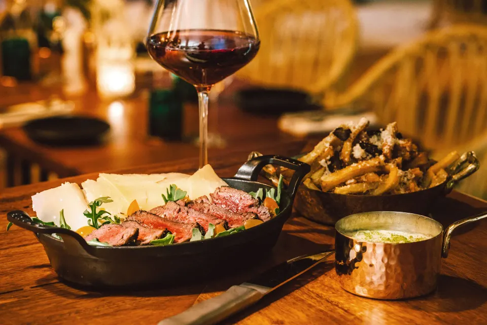 Sliced steak with sides and wine at Hotel Esencia