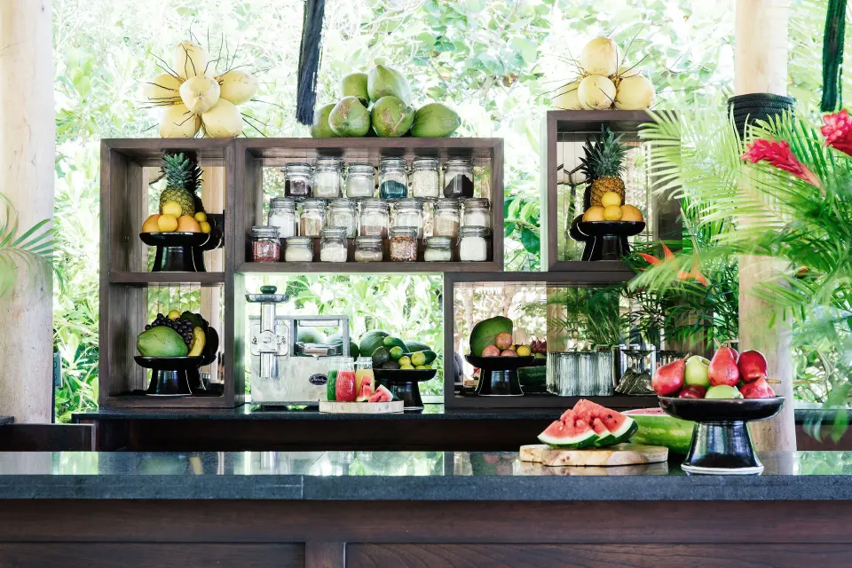 Shelved tropical fruit and jars on a bar counter at Hotel Esencia
