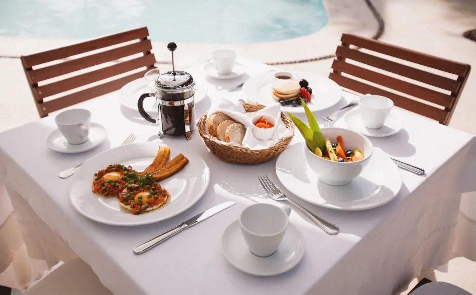 Poolside breakfast spread on a white-tablecloth table at Hotel Esencia