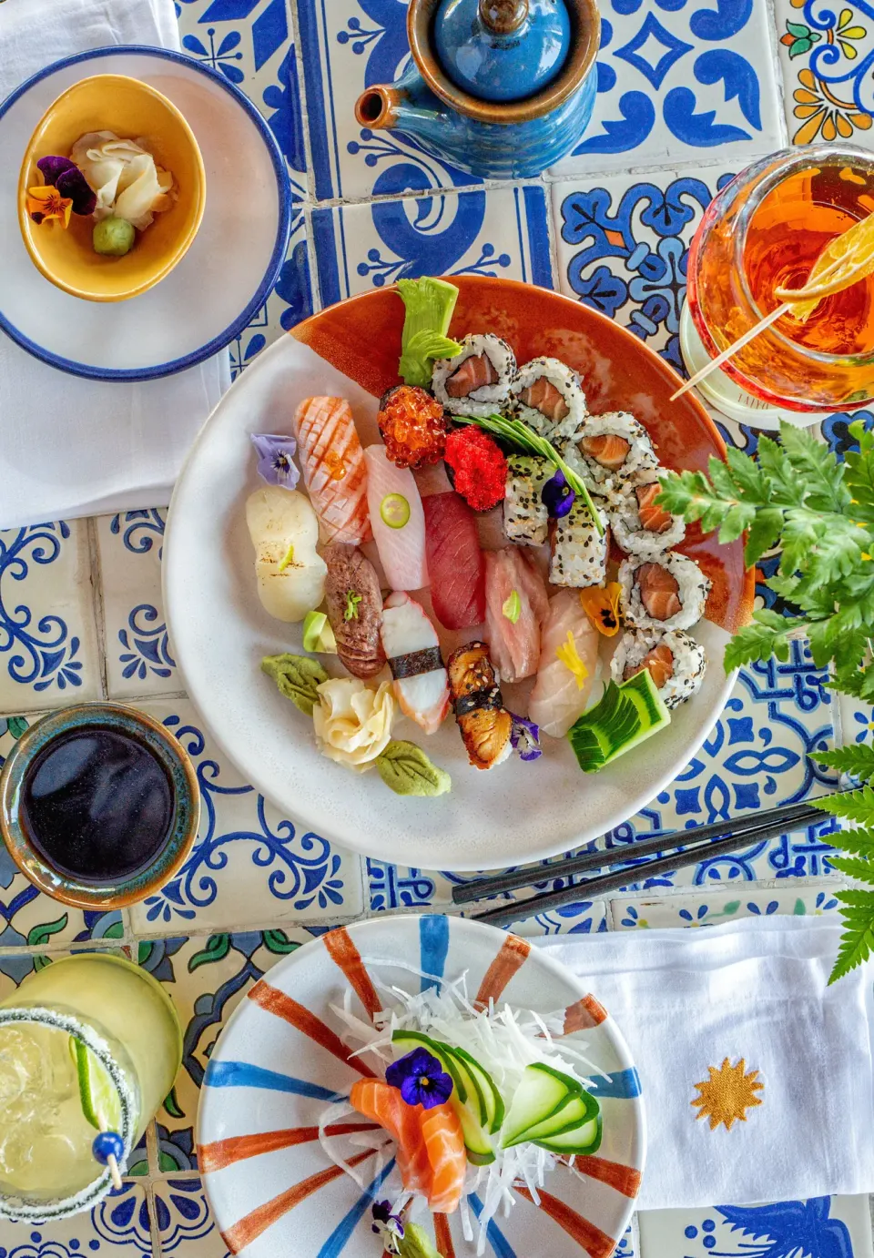 Assorted sushi and rolls on a patterned table at Hotel Esencia