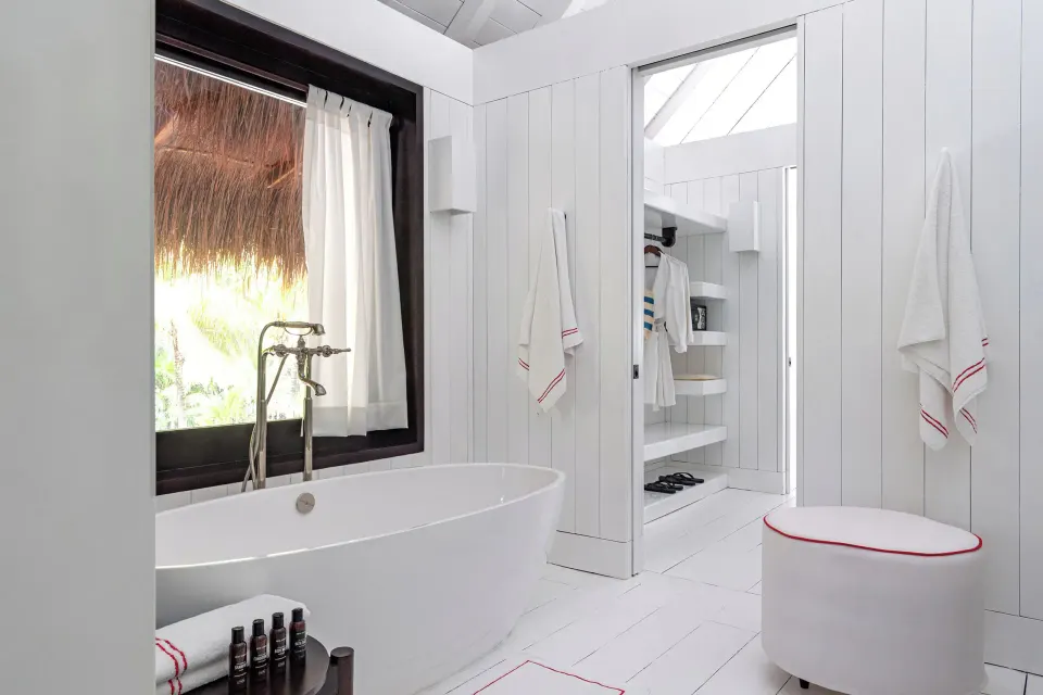 White bathroom with freestanding tub and walk-in closet in the Presidential Bungalow at Hotel Esencia.