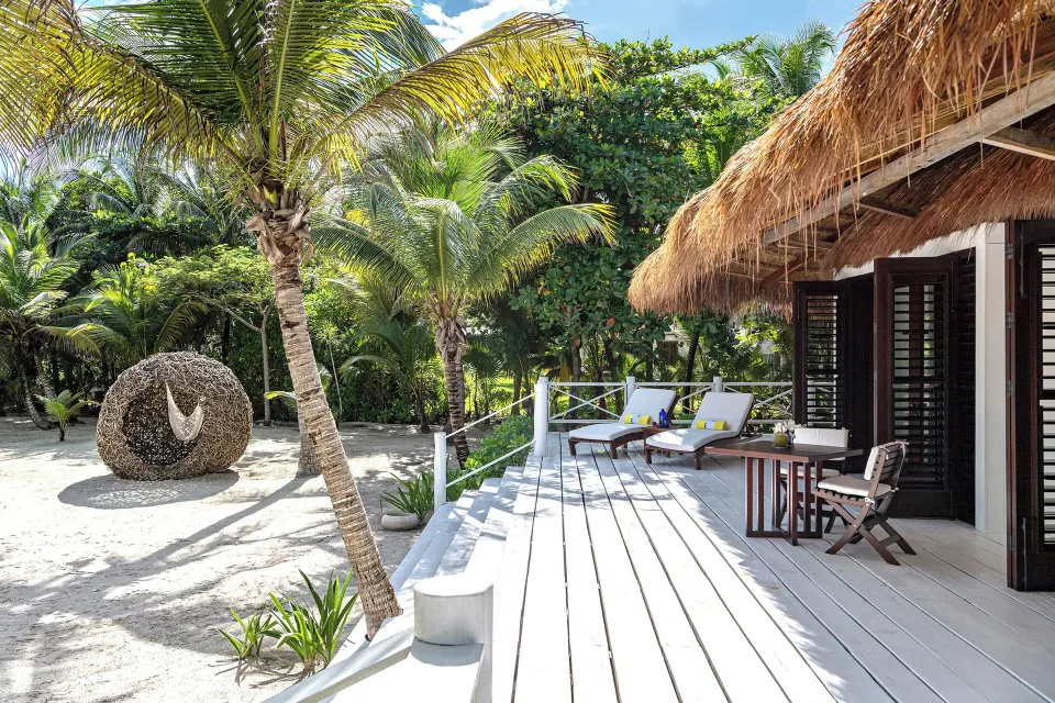 Private bungalow deck with sun loungers and tropical garden at Hotel Esencia