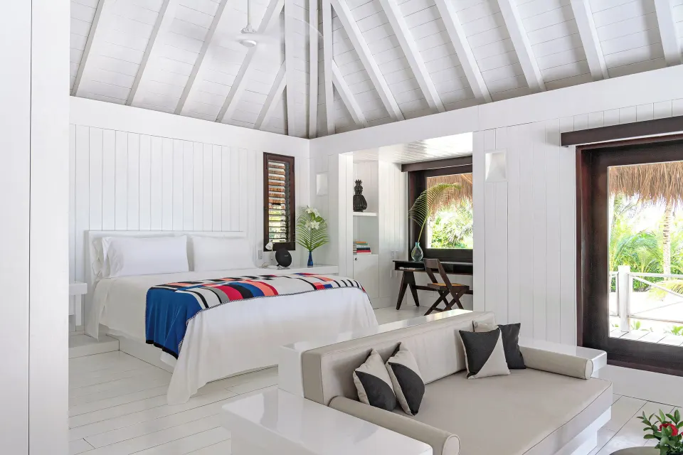 Presidential Bungalow bed and sofa with open balcony doors at Hotel Esencia