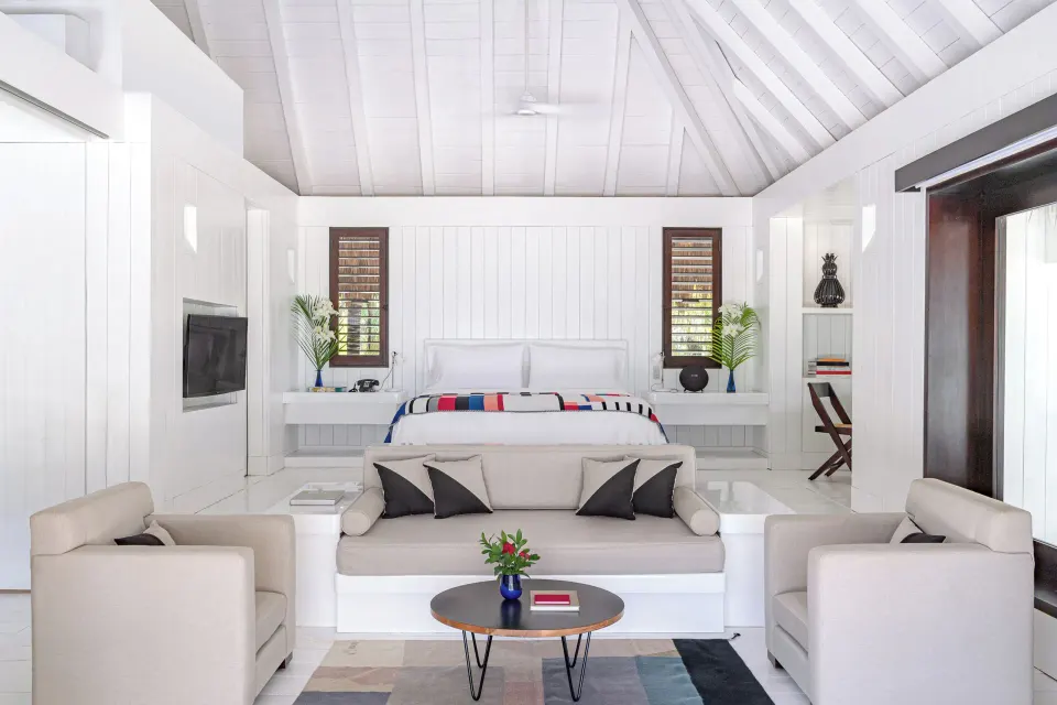 Bright white Presidential Bungalow bedroom with king bed and seating at Hotel Esencia