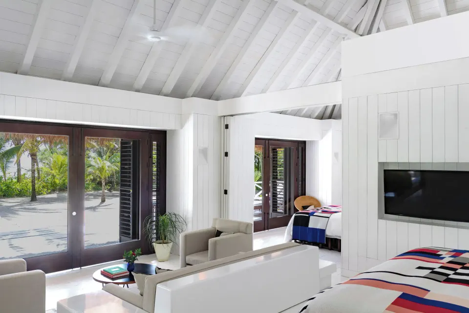 Presidential Bungalow interior showing bed, sofa and large glass doors at Hotel Esencia