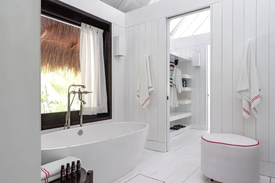 Freestanding tub and open doorway in the Presidential Bungalow bathroom at Hotel Esencia