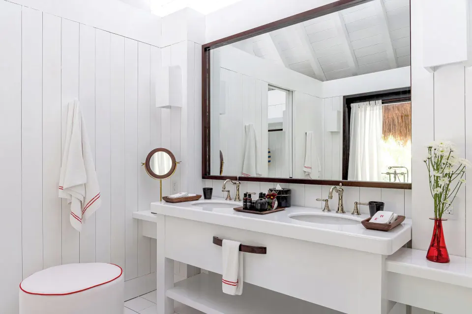 Vanity detail with toiletries and red vase in the Presidential Bungalow bathroom at Hotel Esencia