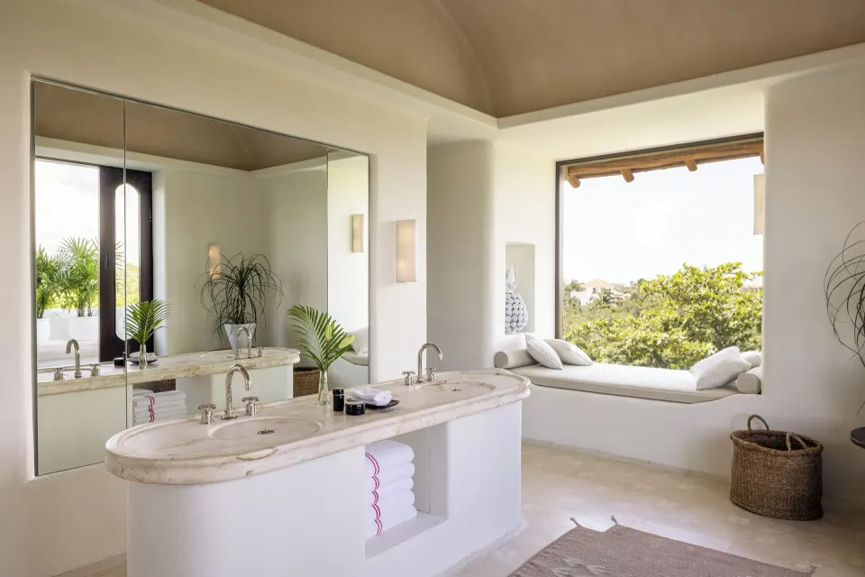 Bright bathroom with double marble vanity and window seat in The Hotel Esencia at Hotel Esencia