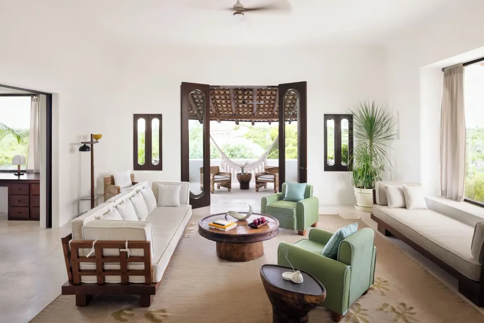 Bright living room with sofas and green armchairs at Hotel Esencia