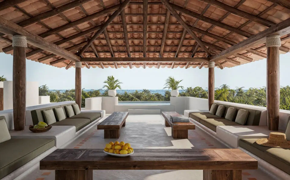 Shaded rooftop lounge with wooden beams and built-in seating at Hotel Esencia