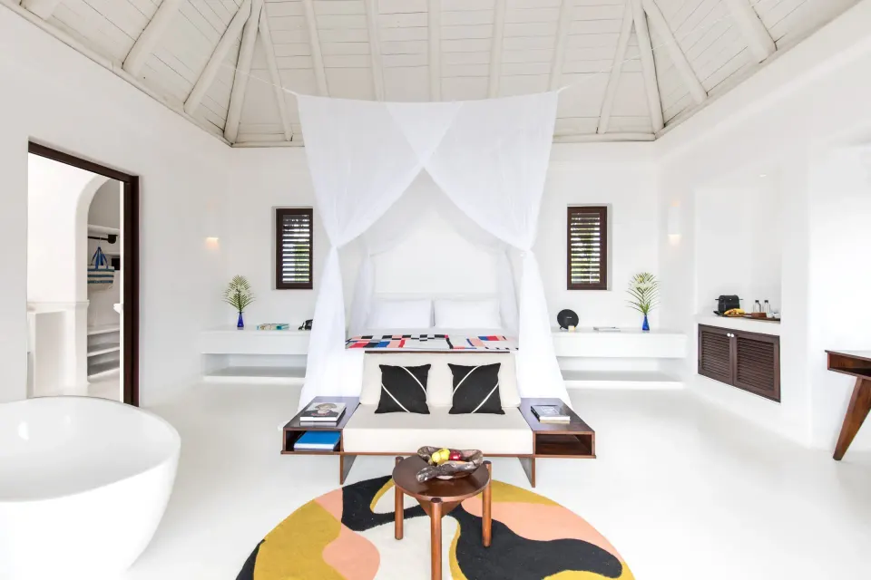 Bright white beach suite interior with canopy bed at Hotel Esencia.
