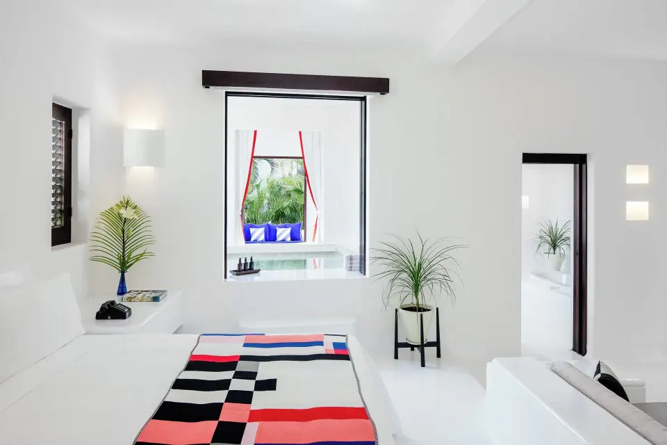 Bedroom ledge with colorful rug and framed opening to outdoor plunge pool at Hotel Esencia