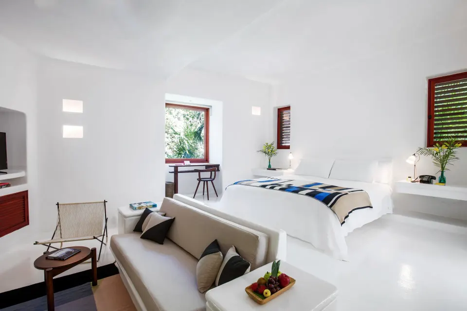 Bright Jungle Suite with king bed, sofa and garden window at Hotel Esencia