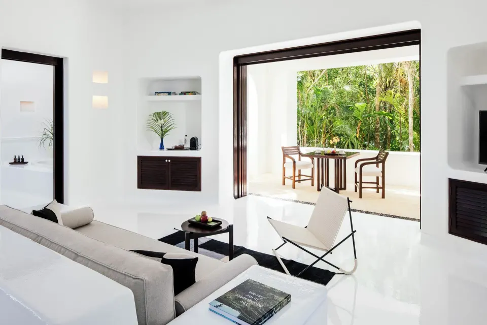 Jungle Suite living area with sofa and open terrace doors to greenery at Hotel Esencia