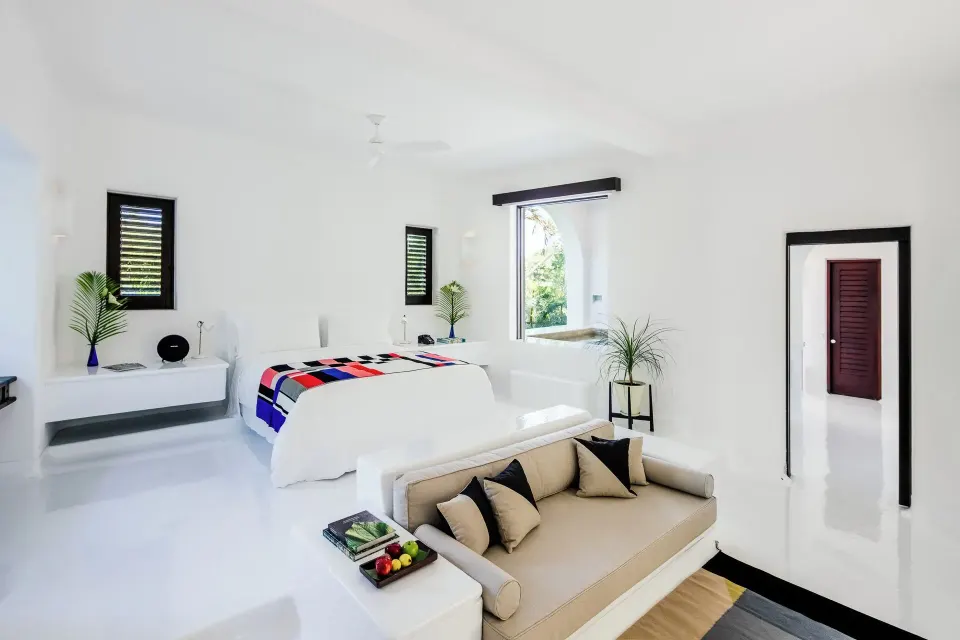 Open-plan Jungle Suite with bed, sofa and doorway to bathroom at Hotel Esencia