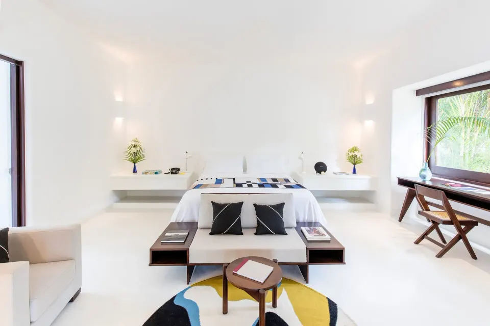 Bright Jungle Suite king bedroom with white interiors at Hotel Esencia