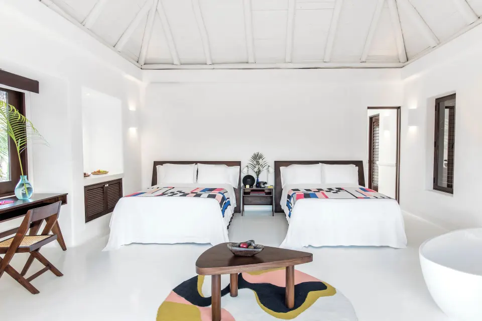 Jungle Suite two beds under a vaulted white ceiling at Hotel Esencia