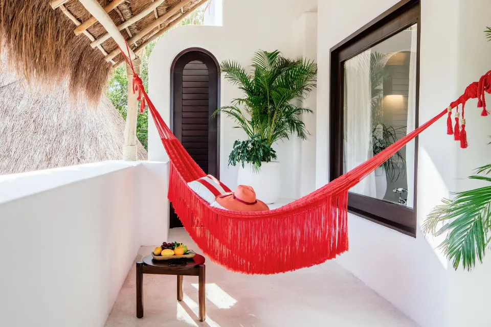 Master Jungle Suite private balcony with red hammock and tropical plants at Hotel Esencia