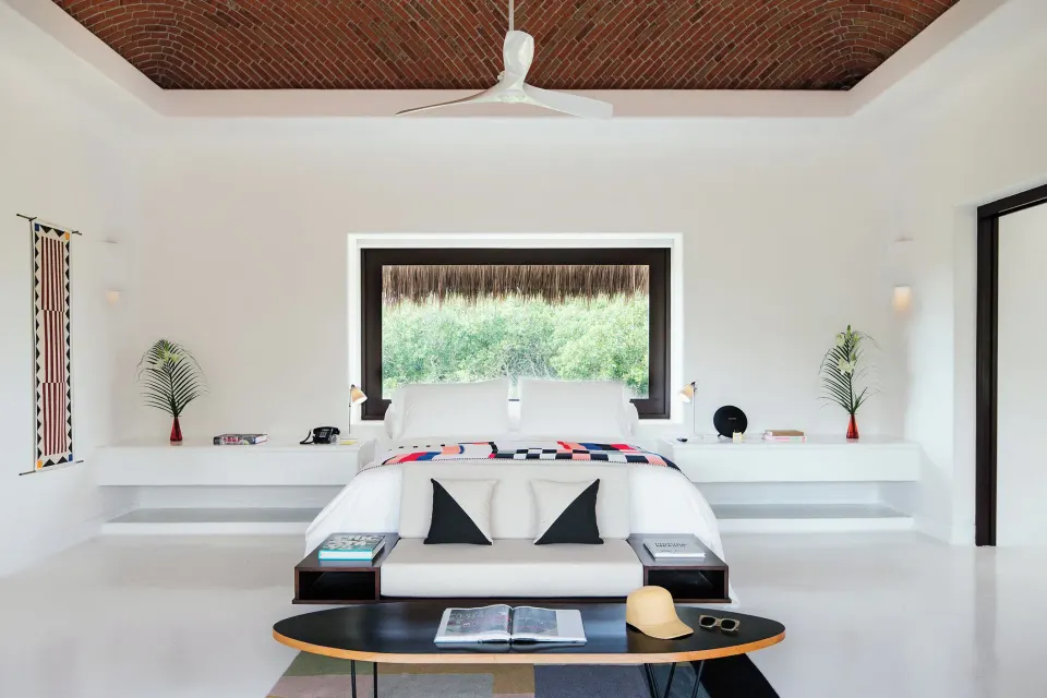 Front view of Master Jungle Suite king bed under vaulted ceiling at Hotel Esencia