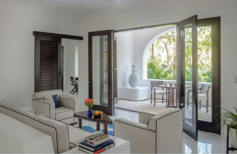 Living area and open doors to a terrace in the Master Jungle Suite at Hotel Esencia