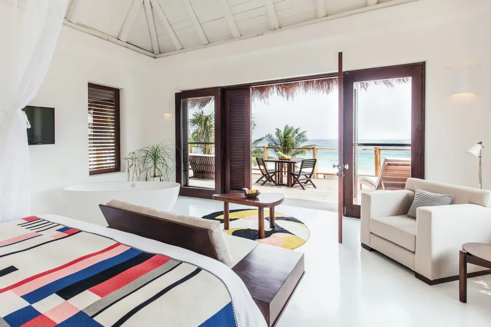 Master suite opening to balcony with sea view and outdoor dining at Hotel Esencia