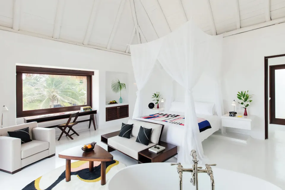 Spacious master bedroom with canopy bed and freestanding tub at Hotel Esencia