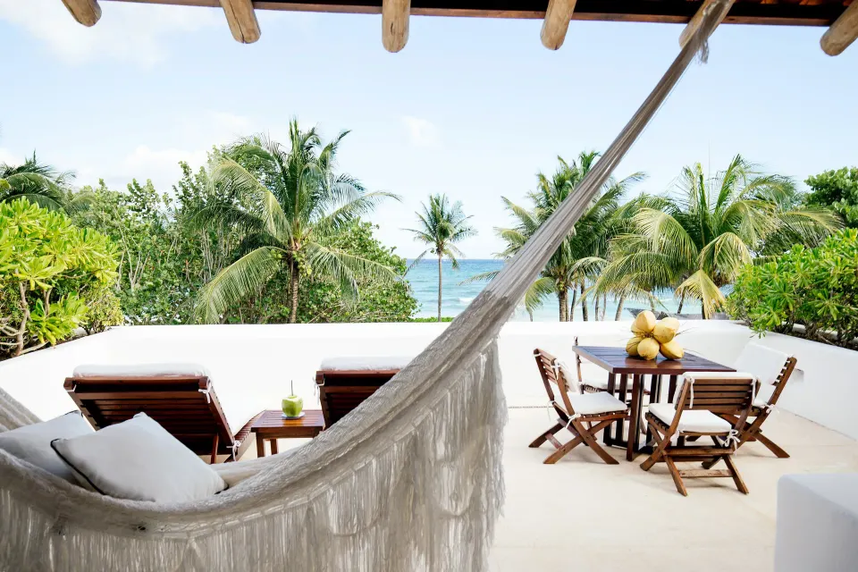 Terrace hammock view overlooking palms and the ocean at Hotel Esencia