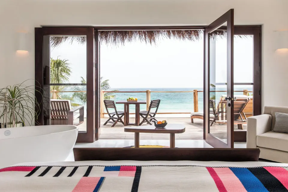Master suite interior with king bed and ocean view balcony at Hotel Esencia