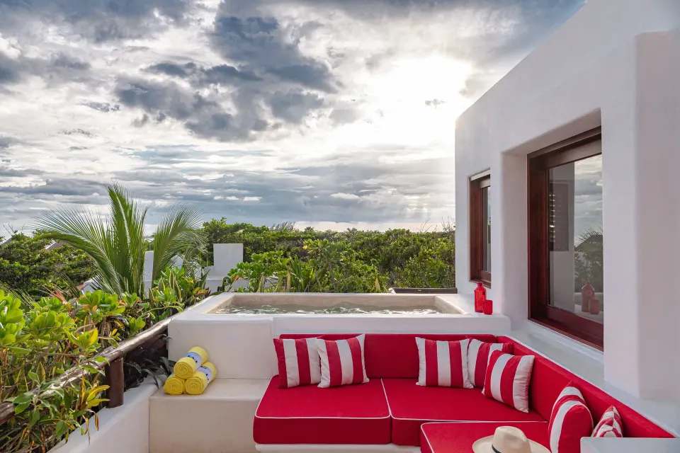 Private balcony seating and plunge tub surrounded by greenery at Hotel Esencia